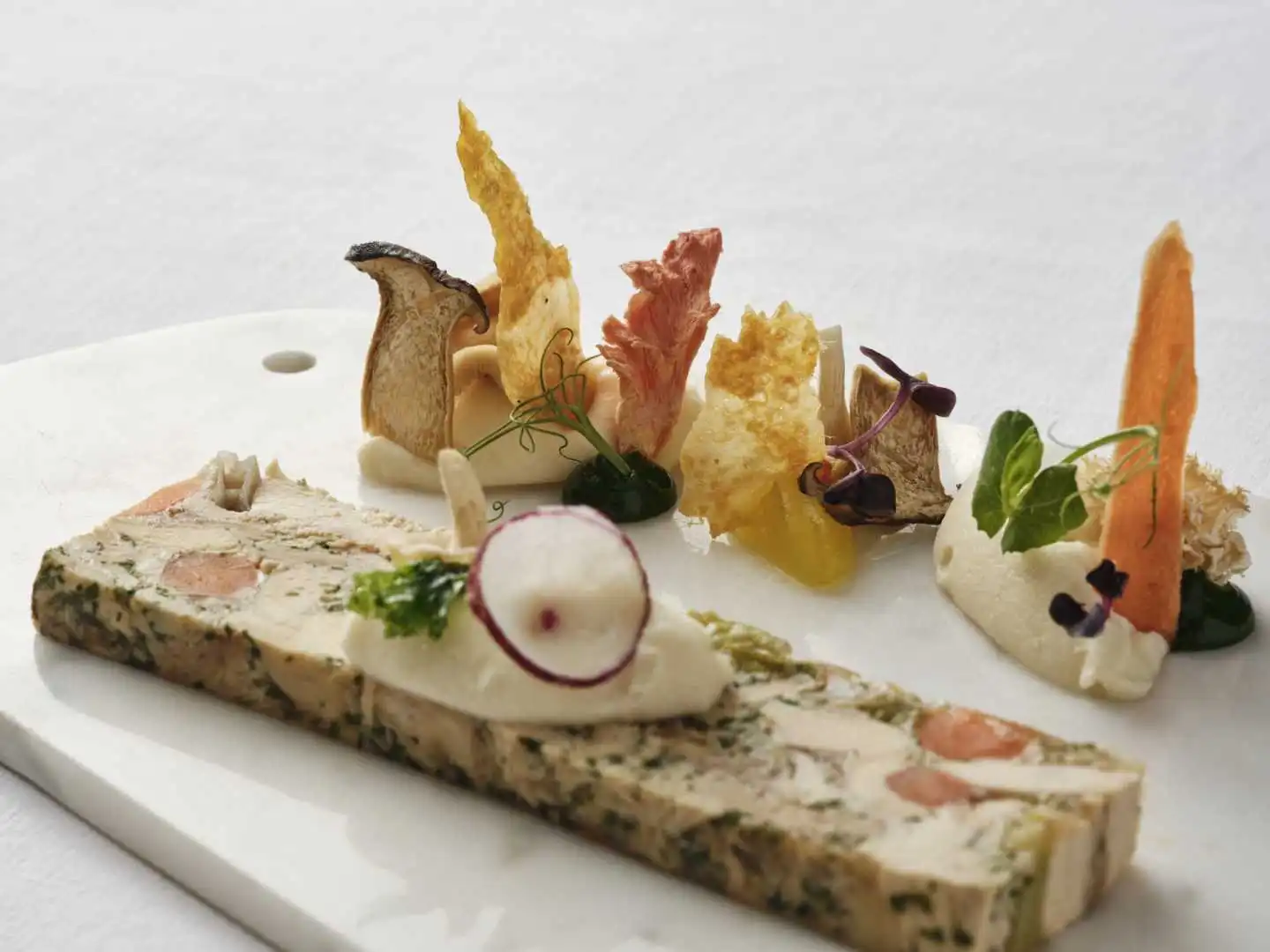 Gourmet dish with assorted garnishes on a white plate.