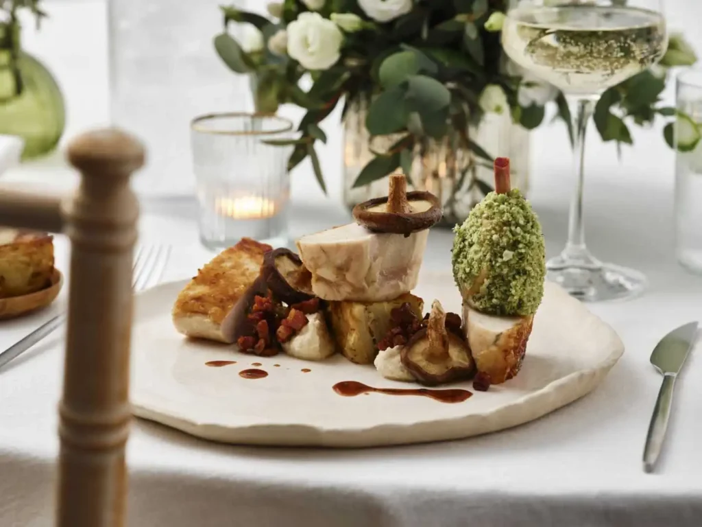 Elegant plated dish with gourmet appetizers and floral centerpiece.